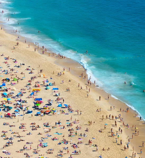 明るい夏の晴れた日の海のビーチでくつろぐ人々 ナザレ ポルトガル — ストック写真