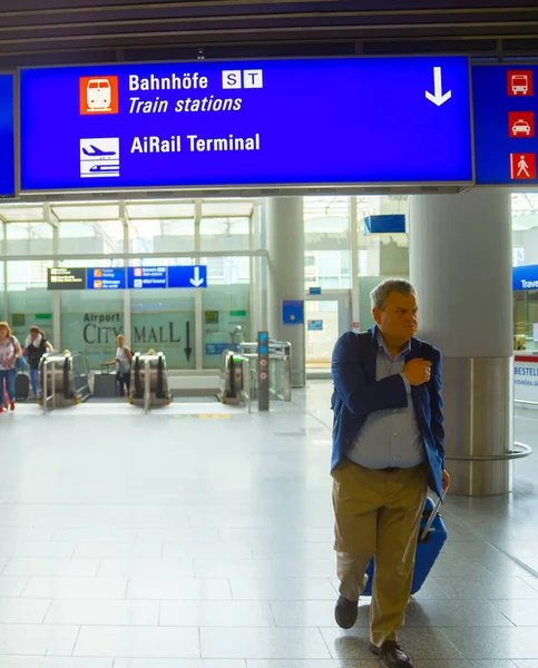 德国美因河畔法兰克福 2018年8月29日 携带行李离开法兰克福机场的人 上面有方向标志的信息板 德国美因河畔法兰克福 — 图库照片