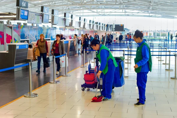 Larnaca Cyprus 2019年2月21日 在国际机场候机楼用扫帚 铲子和水桶清洗女装制服 在背景下排队检查护照 — 图库照片
