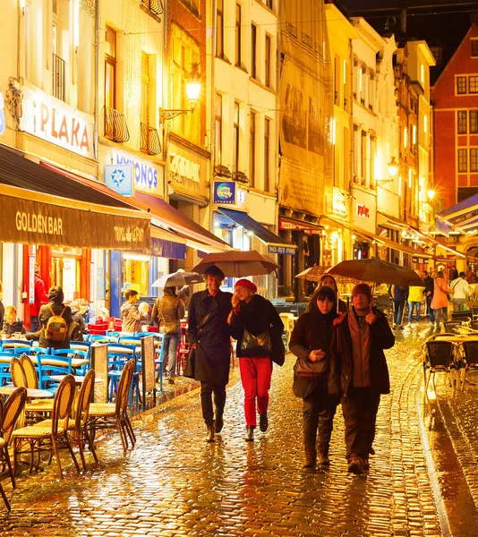 ブリュッセル ベルギー 2019年10月7日 人々は歩いて 夕暮れ時に雨の中でブリュッセルの旧市街のショッピング街のレストランに座っています — ストック写真