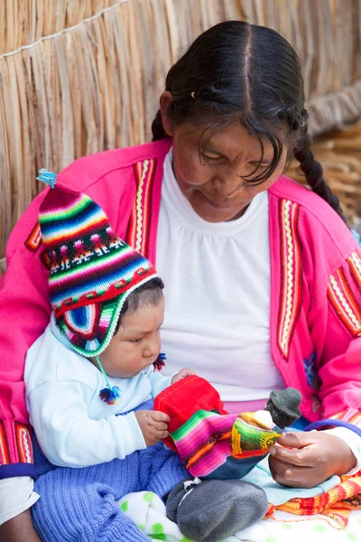 Mujer no identificada en vestido tradicional con niño —  Fotos de Stock