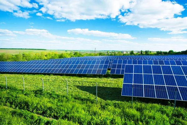 Солнечные батареи на зеленом поле — стоковое фото