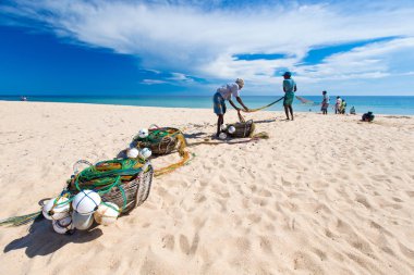 Local fishermen pull a fishing net from Indian Ocean clipart