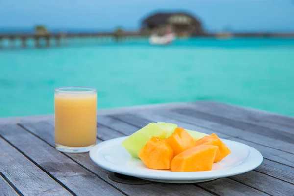 Tallrik med frukt och glas juice — Stockfoto