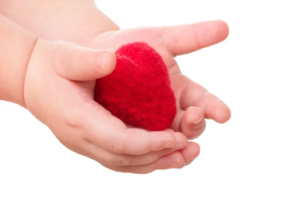 Mani di bambino con cuore giocattolo rosso — Foto Stock