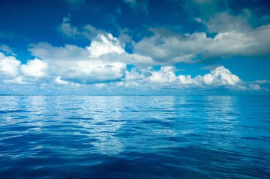 Bulutların üstünde sakin deniz üzerinde mavi gökyüzü