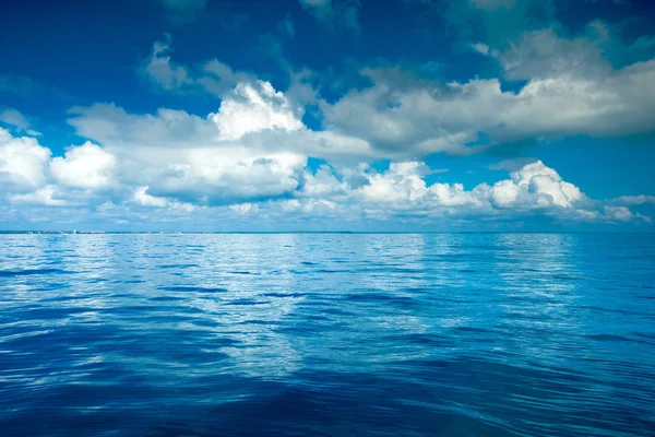 Nubes en el cielo azul sobre el mar tranquilo — Foto de Stock