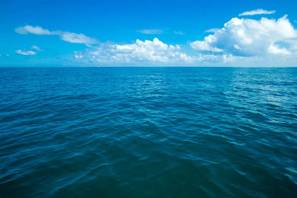 Clouds on blue sky over calm sea — Stock Photo, Image