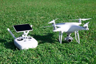 yüksek çözünürlüklü dijital kamera ile dört helikopter ve onun uzaktan kumanda paneli ile smartphone çimenlerin üzerinde robot