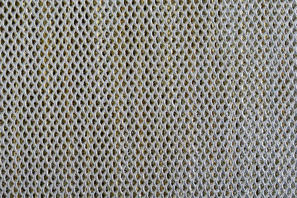 Background sheet of metal covered with lines of circular holes