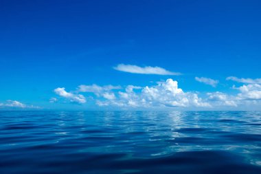 Güzel beyaz bulutların üstünde sakin deniz üzerinde mavi gökyüzü