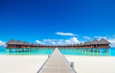 Su bungalov için temiz deniz mavi gökyüzü ve köprü ile tropikal plaj