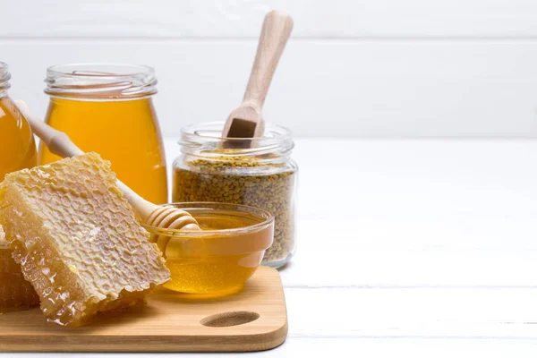 Mel com conta-gotas de mel de madeira na mesa de madeira — Fotografia de Stock