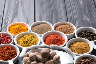 karanlık bir arka plan üzerinde seramik kaplar içinde renkli baharat