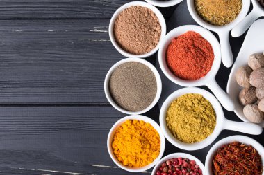 karanlık bir arka plan üzerinde seramik kaplar içinde renkli baharat