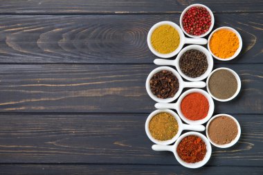 karanlık bir arka plan üzerinde seramik kaplar içinde renkli baharat