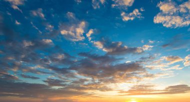 Güneş ışınlarıyla mavi ve turuncu gün batımı gökyüzü. Arkaplan için doğal manzara