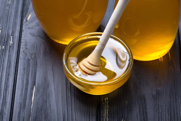 Honey background. Sweet honey in the glass jar . On wooden background.