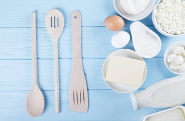Süt ürünleri mavi ahşap masa üzerinde. Ekşi krema, süt, peynir, yumurta ve tereyağı. Kopya alanı ile Üstten Görünüm