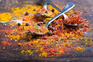 Kaşık koyu ahşap arka plan üzerinde renkli baharat