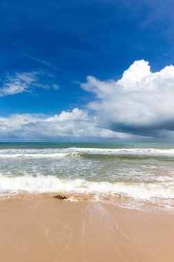 Açık plaj ve sıcak tropikal deniz mavi gökyüzü beyaz bulutlar ile karşı.