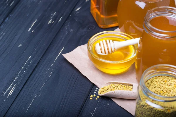 蜂蜜蜂蜜ディッパー スクープと木製の背景に花粉が付いている瓶で — ストック写真