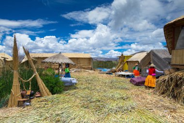 Peru - 11 Mayıs 2015: Kimliği belirsiz kadın geleneksel elbise hoş geldiniz turistler Uros Adası