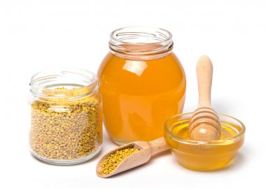 ahşap kepçe ve beyaz zemin üzerine bal