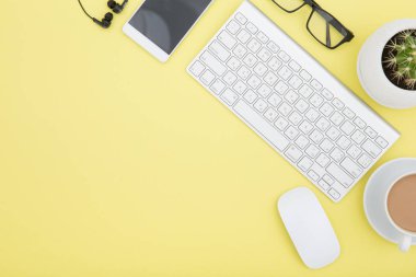 tablet, klavye, kahve fincanı ve gözlük ile çalışma alanı alanı Sarı zemin üzerine kopyalayın. Üstten Görünüm.
