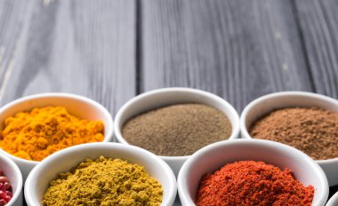 koyu arka plan üzerinde seramik kaplar içinde renkli baharat