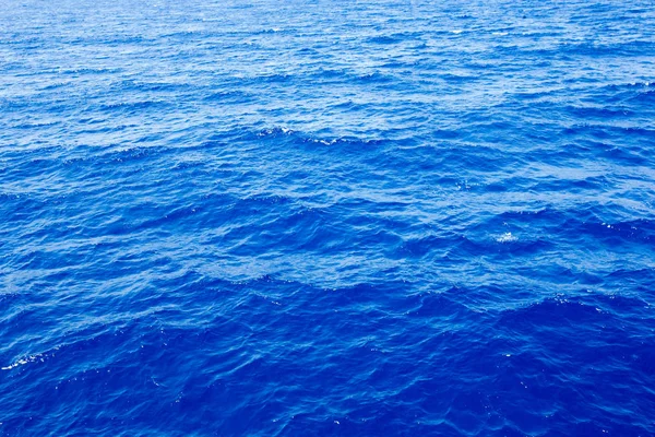 Meereshintergrund. blaues Wasser mit Sonnenreflexionen — Stockfoto