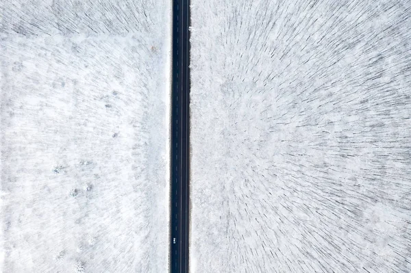 Uitzicht vanuit de lucht op het winterbos en de weg. Winterlandschap — Stockfoto