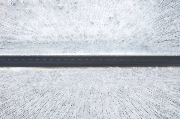 Uitzicht vanuit de lucht op het winterbos en de weg. Winterlandschap — Stockfoto