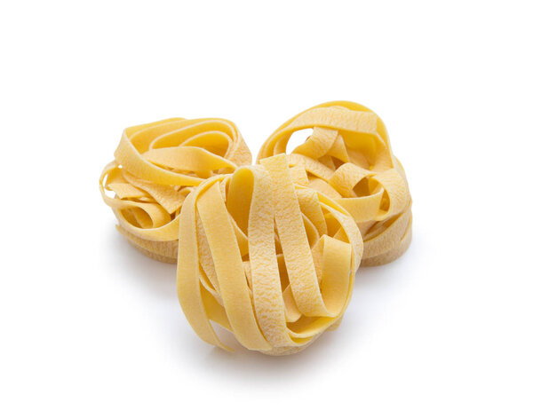 Pasta nest. Uncooked nest of tagliatelle pasta isolated on white