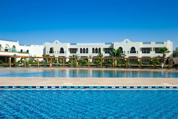 Piscina con cocotero y sombrilla blanca —  Fotos de Stock