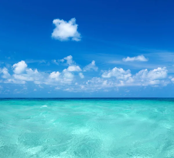 Mar y cielo azul. Agua azul del mar y cielo con manchas blancas y esponjosas. —  Fotos de Stock