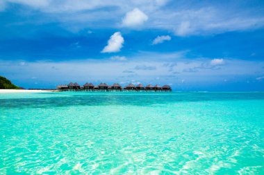 Deniz ve mavi gökyüzü. Mavi deniz suyu ve beyaz kabarık bulutlu gökyüzü. Mavi denizin yatay arka planı. Tropikal manzara