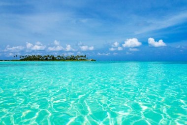 Deniz ve mavi gökyüzü. Mavi deniz suyu ve beyaz kabarık bulutlu gökyüzü. Mavi denizin yatay arka planı. Tropikal manzara