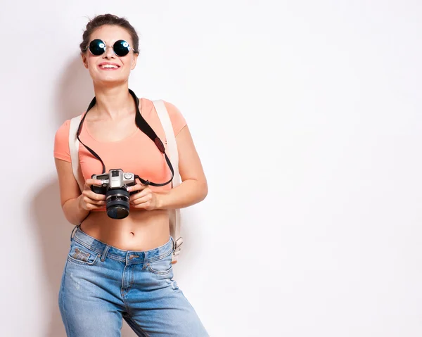 Gelukkig jonge hipster vrouw in glazen houdt retro fotocamera — Stockfoto