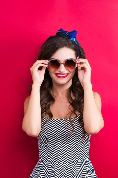Mooie jonge sexy pin-up meisje met verrast uitdrukking, op rode achtergrond — Stockfoto