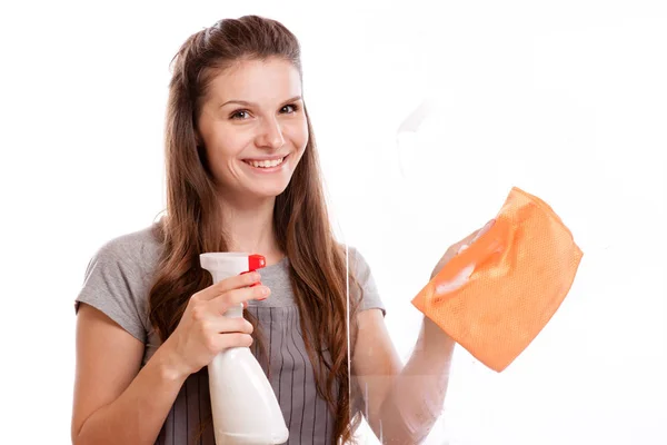 Människor, hushållsarbete och hushållning koncept - glad kvinna i handskar rengöring fönster med trasa och rengöringsmedel spray hemma Royaltyfria Stockbilder