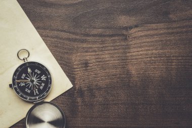 Pusula ve eski kağıt üzerinde kahverengi ahşap masa