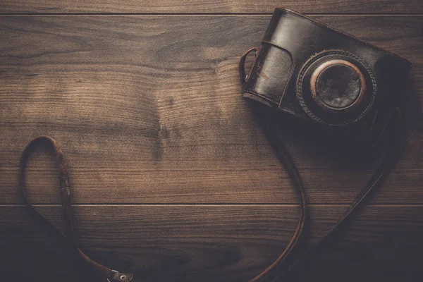 wooden background with retro still camera