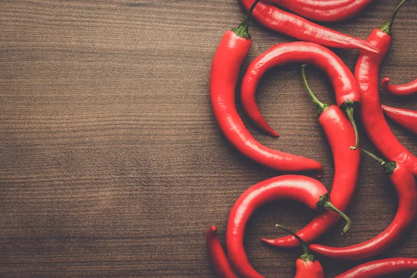Red hot chilli papričky na dřevěný stůl — Stock fotografie