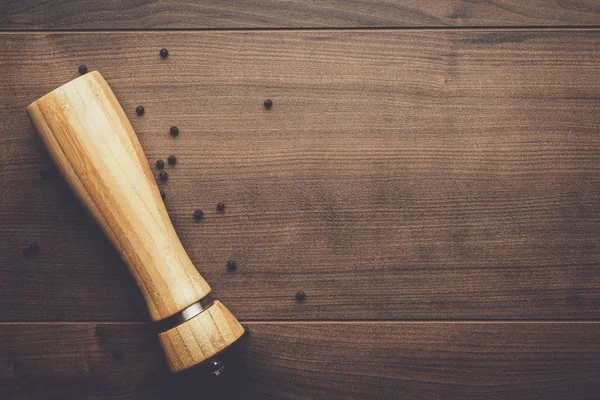 Fából készült borsőrlő az asztalon — Stock Fotó
