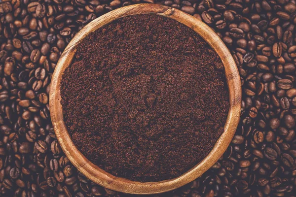 Granos de café y tazón de madera lleno de café molido — Foto de Stock