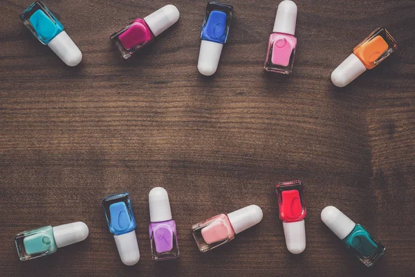 Nail polish bottles on brown wooden table — Stock Photo, Image