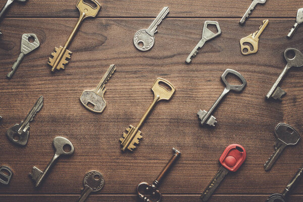 many different keys on wooden table