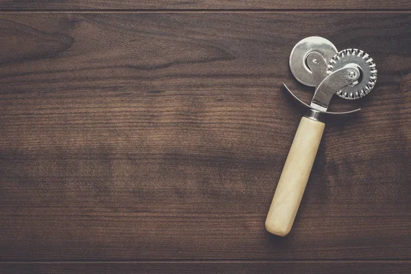 Pizza cutter op houten tafel — Stockfoto