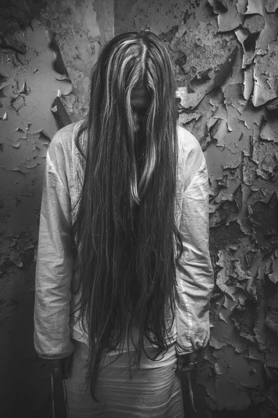 Zumbi com cabelo loong em um prédio abandonado — Fotografia de Stock